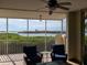 Relaxing screened balcony with wicker chairs and stunning water views at 13313 Gasparilla Rd # C205, Placida, FL 33946