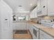 White kitchen with stainless steel appliances and ample counter space at 13313 Gasparilla Rd # C205, Placida, FL 33946