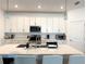 Modern kitchen featuring white cabinets, stainless steel appliances, and a stylish island with seating at 19060 Moscato Ct, Venice, FL 34293