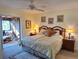 Main bedroom with king bed and access to a screened-in porch at 26 Quails Run Blvd # 7, Englewood, FL 34223