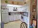 Bright kitchen featuring white cabinets and appliances at 26 Quails Run Blvd # 7, Englewood, FL 34223