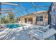 Screened pool area with lounge chairs and a view of the surrounding landscape at 2803 Sawgrass Ct, Port Charlotte, FL 33953