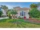 Tan one-story house with a red door, two-car garage, and lush landscaping at 2803 Sawgrass Ct, Port Charlotte, FL 33953