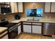 Bright kitchen featuring stainless steel appliances, wood cabinets, and a pass-through window to living area at 514 Pine Hollow Cir # 514, Englewood, FL 34223