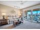 Bright living area with balcony access overlooking serene views, ceiling fan, and neutral color scheme at 514 Pine Hollow Cir # 514, Englewood, FL 34223