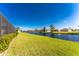 The backyard features a lush green lawn and scenic water view, offering a serene outdoor space at 849 Rotonda Cir, Rotonda West, FL 33947
