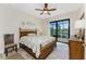 Bedroom with view, features wood floors, ceiling fan, and sliding glass doors to patio at 849 Rotonda Cir, Rotonda West, FL 33947