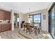 Bright dining area with wood-look flooring and sliding glass doors overlooking the pool and backyard at 849 Rotonda Cir, Rotonda West, FL 33947