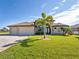 Lovely home showcasing a lush green lawn, a circular driveway, a three-car garage, and an elegant arched entryway framed by columns at 849 Rotonda Cir, Rotonda West, FL 33947