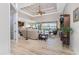 Bright and airy living room with high ceilings, fan and sliding glass doors to the lanai and pool area beyond at 849 Rotonda Cir, Rotonda West, FL 33947