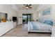 Bright main bedroom featuring wood-look flooring, tray ceilings, and sliding door access to lanai at 849 Rotonda Cir, Rotonda West, FL 33947