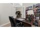Home office space featuring a large desk, dark wood bookshelves, and glass panel doors at 849 Rotonda Cir, Rotonda West, FL 33947
