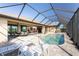 A screened-in pool with lounge chairs and an outdoor dining area, perfect for entertaining at 849 Rotonda Cir, Rotonda West, FL 33947