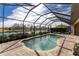 Screened in pool with beautiful lake view, brick floors, and lounge chairs at 849 Rotonda Cir, Rotonda West, FL 33947