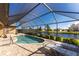 Private pool with screened enclosure overlooking a serene pond, ideal for outdoor relaxation at 849 Rotonda Cir, Rotonda West, FL 33947
