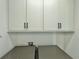 Laundry room with white cabinets and gray washer/dryer at 19060 Moscato Ct, Venice, FL 34293