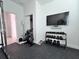 Home gym with dumbbell rack and large flat screen TV at 19060 Moscato Ct, Venice, FL 34293