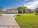 House exterior featuring a three-car garage and lush landscaping at 849 Rotonda Cir, Rotonda West, FL 33947