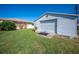 Detached garage with roll-up door and grassy yard at 976 Euclid Rd, Venice, FL 34293