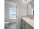 Bathroom with single vanity, toilet, and window at 19196 Raymond Ave, Port Charlotte, FL 33954