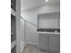 Modern bathroom with gray cabinets, a walk-in shower, and a large mirror at 19196 Raymond Ave, Port Charlotte, FL 33954