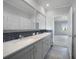 Double vanity bathroom with gray cabinets and a view of a bedroom at 19196 Raymond Ave, Port Charlotte, FL 33954