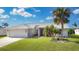 One-story home with two car garage, palm tree, and manicured lawn at 254 Bunker Rd, Rotonda West, FL 33947