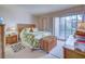 Tropical bedroom with wicker furniture and access to a private patio at 19 Quails Run Blvd # 2, Englewood, FL 34223