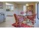 Dining area with kitchen view, glass table, and patterned chairs at 19 Quails Run Blvd # 2, Englewood, FL 34223