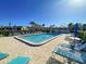 Inviting community pool with lounge chairs and umbrellas at 19 Quails Run Blvd # 2, Englewood, FL 34223