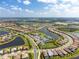 Aerial view showing community homes surrounding a lake and recreational amenities at 13077 Rinella St, Venice, FL 34293