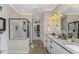 Bathroom with double vanity, walk-in shower, and large mirror at 13077 Rinella St, Venice, FL 34293
