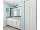 Bathroom with white cabinets, granite countertop, and a large mirror at 153 Broadmoor Ln, Rotonda West, FL 33947