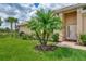 Tan house with lush landscaping, palm trees and a large lawn at 13104 Creekside Ln, Port Charlotte, FL 33953