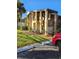 Exterior view of condo building with parking and landscaping at 26 Quails Run Blvd # 7, Englewood, FL 34223