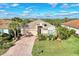 One-story house with a brick driveway, lush landscaping, and two-car garage at 13033 N Marsh Dr, Port Charlotte, FL 33953