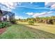 Landscaped backyard with grassy area and screened patio at 13033 N Marsh Dr, Port Charlotte, FL 33953
