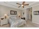 Comfortable bedroom with ceiling fan, neutral decor, and ensuite bathroom access at 13033 N Marsh Dr, Port Charlotte, FL 33953
