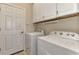 Laundry room with washer, dryer, and overhead cabinets at 13033 N Marsh Dr, Port Charlotte, FL 33953