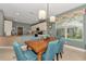 Dining area features a wooden table, teal chairs, and views to the kitchen and backyard at 13392 Golf Pointe Dr, Port Charlotte, FL 33953