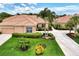 Single-story home with tile roof, two-car garage, and lush landscaping at 2844 Myakka Creek Ct, Port Charlotte, FL 33953