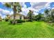 Landscaped backyard with a view of the home and surrounding nature at 2844 Myakka Creek Ct, Port Charlotte, FL 33953