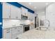 Stylish kitchen with gray cabinets, granite counters, and a blue accent wall at 10985 Trevino St, Englewood, FL 34223