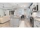 Open kitchen with gray cabinets, granite island, and stainless steel appliances at 10985 Trevino St, Englewood, FL 34223