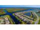 Aerial view of waterfront community with houses lining canals and a central pond at 15048 Spanish Point Dr, Port Charlotte, FL 33981