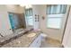 This bathroom features decorative window shades, granite vanity top and tiled shower at 15048 Spanish Point Dr, Port Charlotte, FL 33981