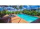 Screened in private pool with in-ground spa, lounge chairs, umbrella, and tropical plants at 15048 Spanish Point Dr, Port Charlotte, FL 33981