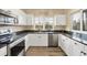 Bright kitchen with white cabinets, dark countertops, stainless steel appliances, and windows at 3929 Cape Haze Dr # 105, Rotonda West, FL 33947