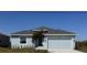 Charming single-story home with a gray roof, an attached two-car garage, and a well-maintained lawn at 450 Albatross Rd, Rotonda West, FL 33947