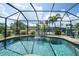 Inviting kidney-shaped pool with screened enclosure and water feature at 9381 St Paul Dr, Port Charlotte, FL 33981